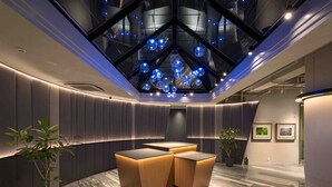 A modern interior with a skylight, wooden furniture, and a marble floor. - EN HOTEL Hiroshima (Hiroshima)