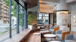 A modern interior with seating areas, large windows, and a view of the street. - EN HOTEL Hiroshima (Hiroshima)