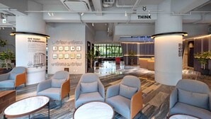 A modern hotel lobby with seating, artwork, and a 'THINK' sign. - EN HOTEL Hiroshima (Hiroshima)