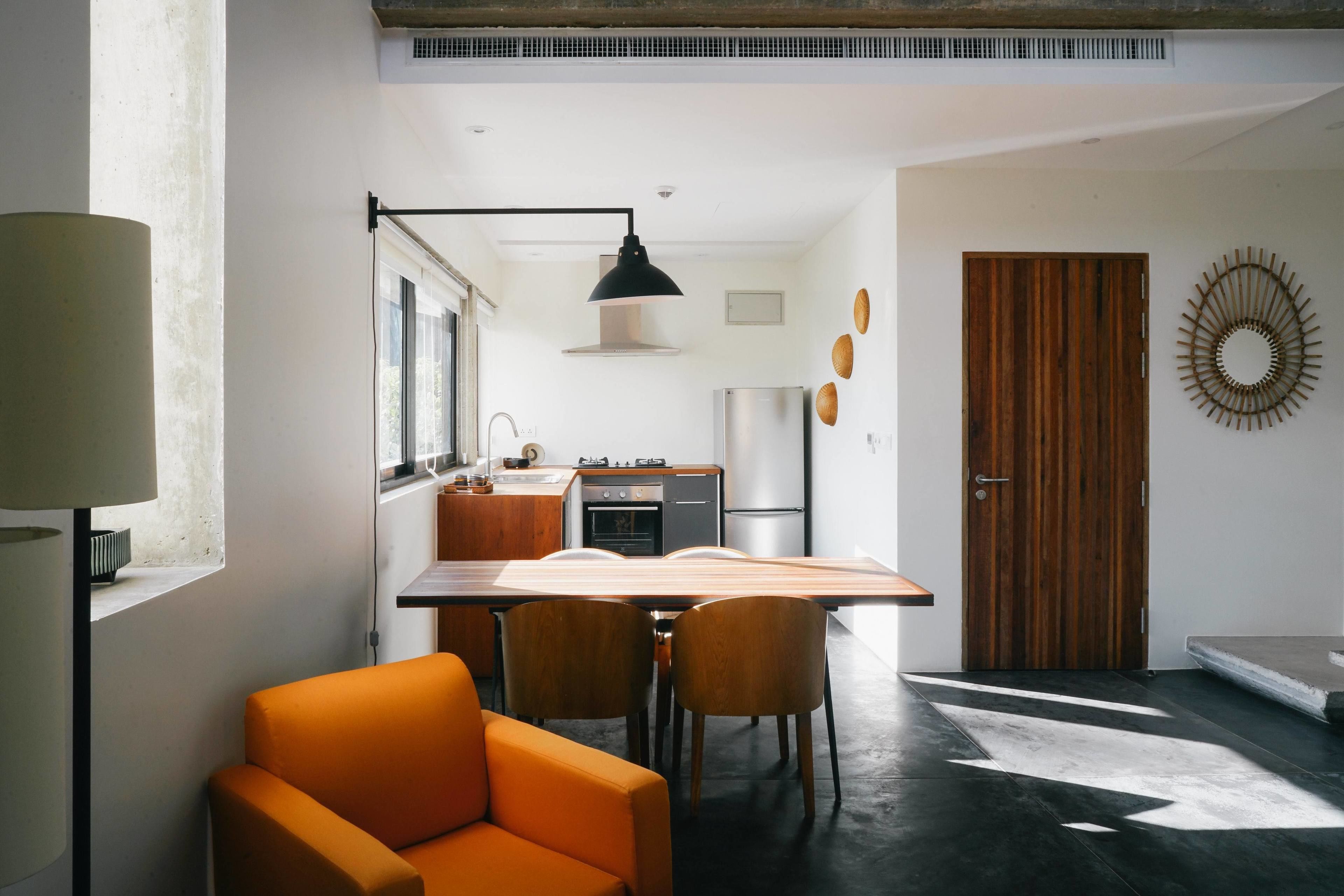 Une cuisine moderne avec un coin repas, comprenant une grande table, des chaises et un luminaire suspendu.