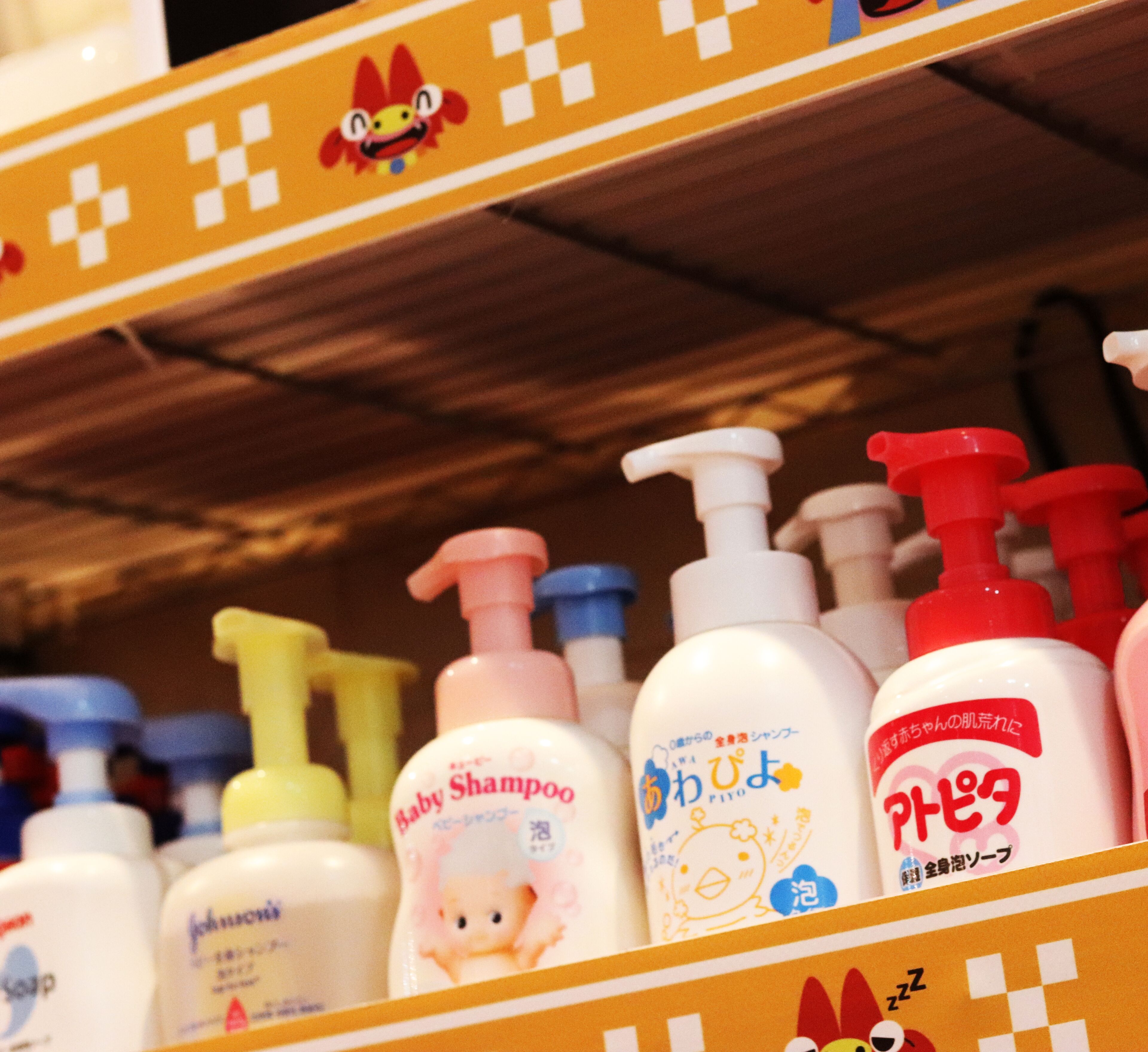 A shelf with various baby shampoo bottles.