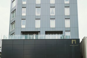 A modern hotel building with a flat facade, multiple windows, and a glass balcony. - The Gate Hotel Kaminarimon by Hulic (Tokyo)