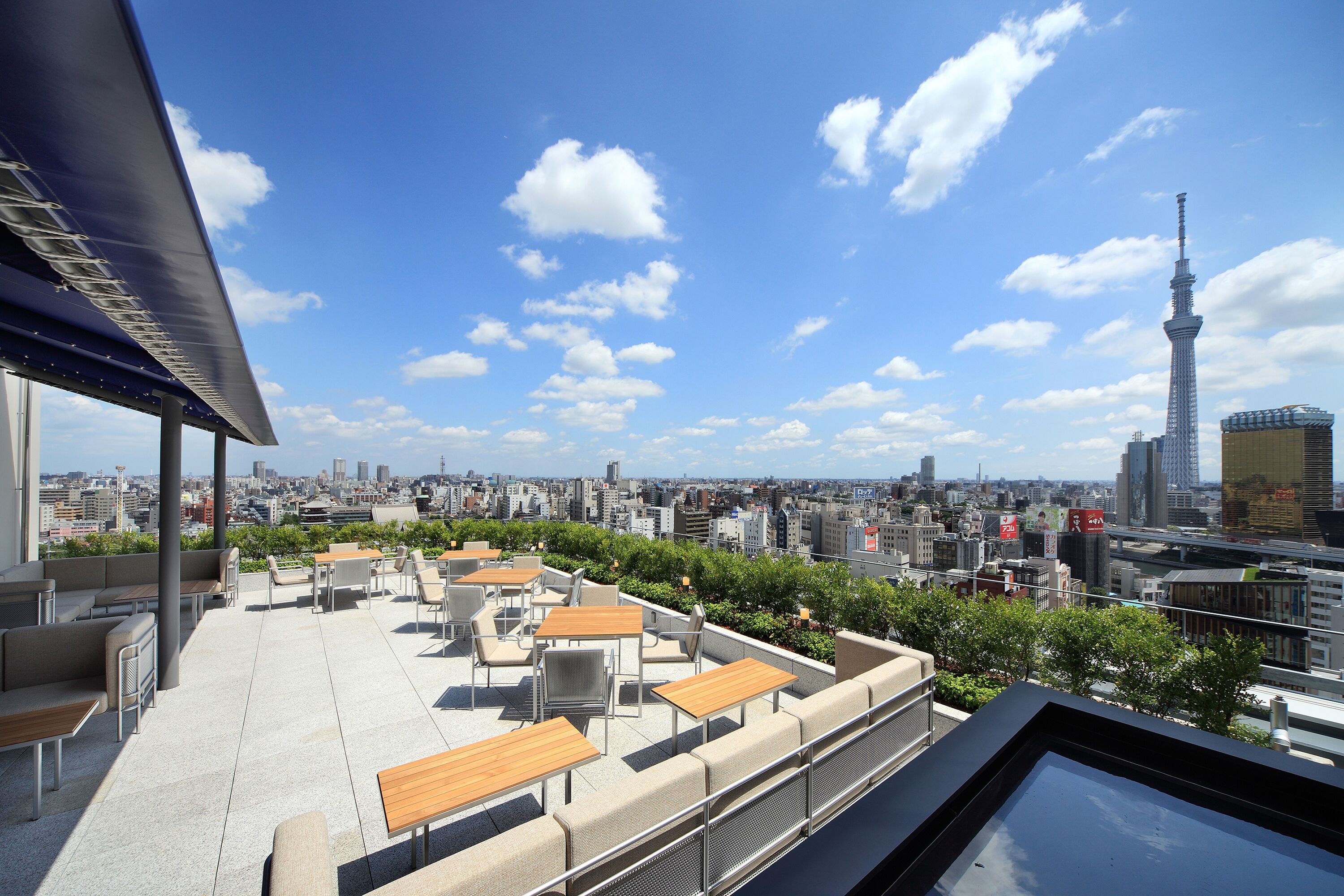 A rooftop terrace with outdoor seating and a cityscape view.