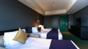 Habitación de hotel con dos camas, un sofá, un televisor y una puerta verde.