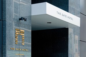 Ein Hotelschild mit dem Namen "The Gate Hotel" und einem goldfarbenen Logo.