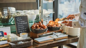 Un buffet proposant des croissants, du pain et de la confiture d’orange.