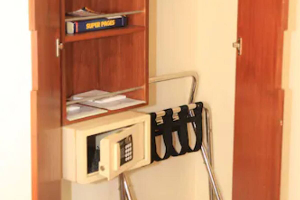 A wooden wardrobe with shelves, a hanging rack, and a small desk with a chair.