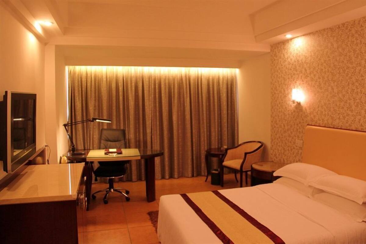 Une chambre d’hôtel équipée d’un lit, d’un bureau, d’une chaise et d’un téléviseur.