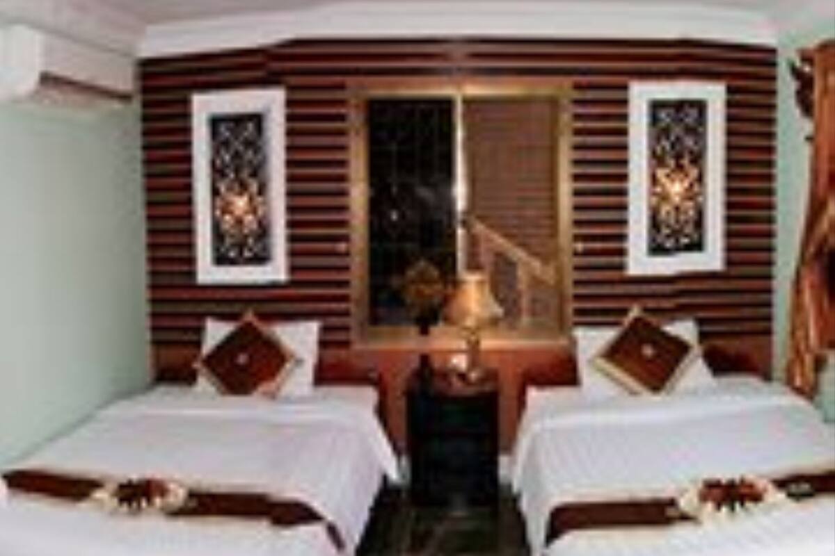 A hotel room with two beds, a nightstand, and a mirror.
