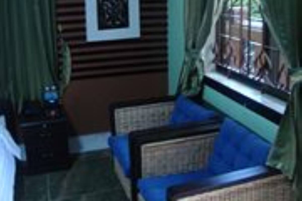 A room with a sofa, a small table, and a window with curtains.