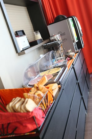 Un buffet proposant une variété de plats et une machine à café.