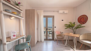 Una habitación de hotel moderna con balcón, zona de comedor y área de estar.