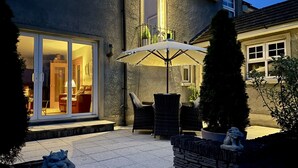 Un espace patio aménagé avec du mobilier d’extérieur et une statue.