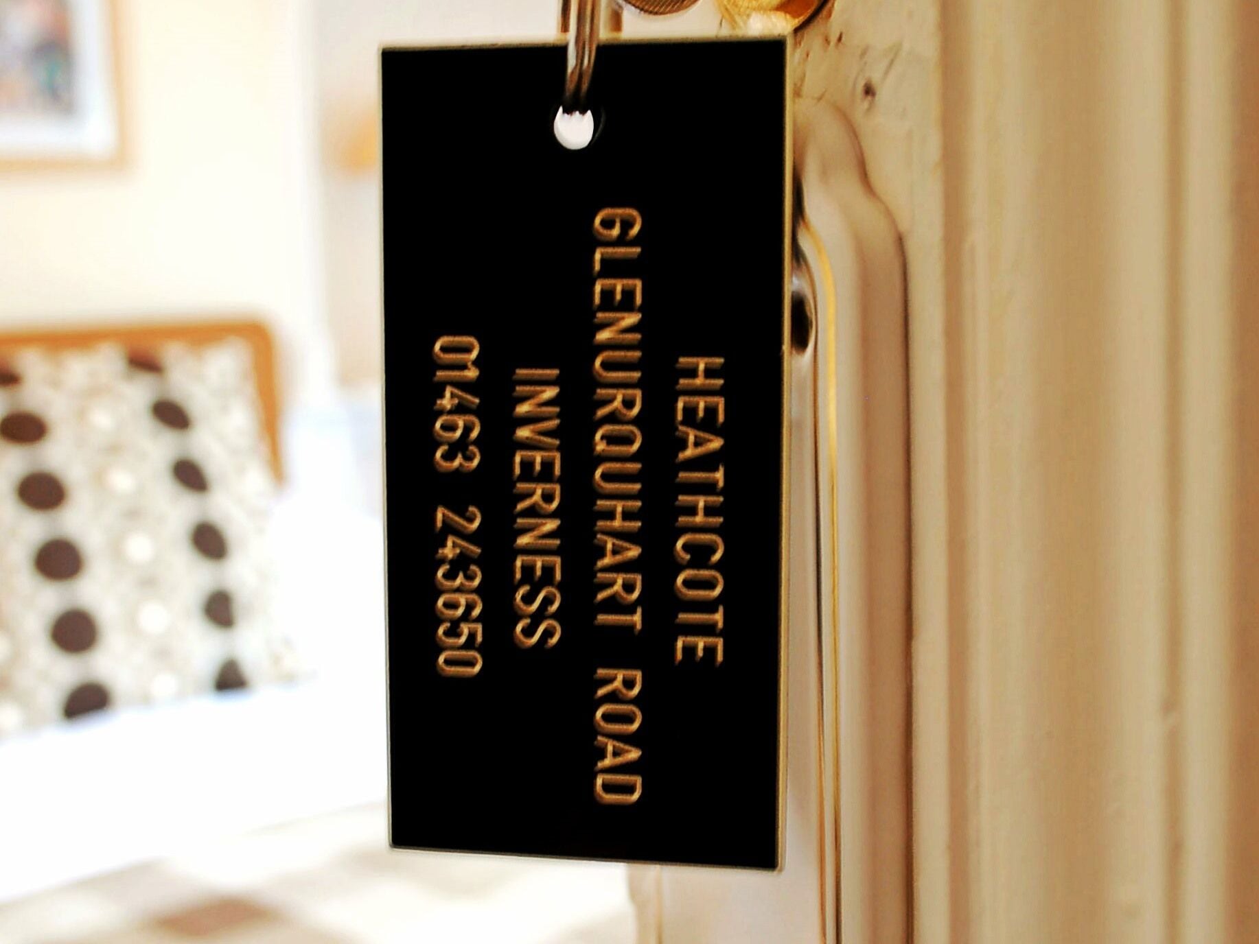 Un letrero de hotel negro con el nombre 'HEATHCOTE' y 'Glenrohan Road', junto con un número de teléfono.