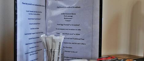 A menu for breakfast at Heathcote B&B listing items like grilled bacon, pork sausage, mushrooms, tomato, fried egg, toast, whole meal, white bread, fruit, traditional teas, cappuccino, de-cafe coffee, hot chocolate, marmite, and Bovril.
