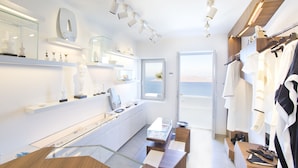 A modern bathroom with a glass shower enclosure, a vanity with a mirror, and a towel rack. - Grace Hotel, Auberge Collection (Santorini)