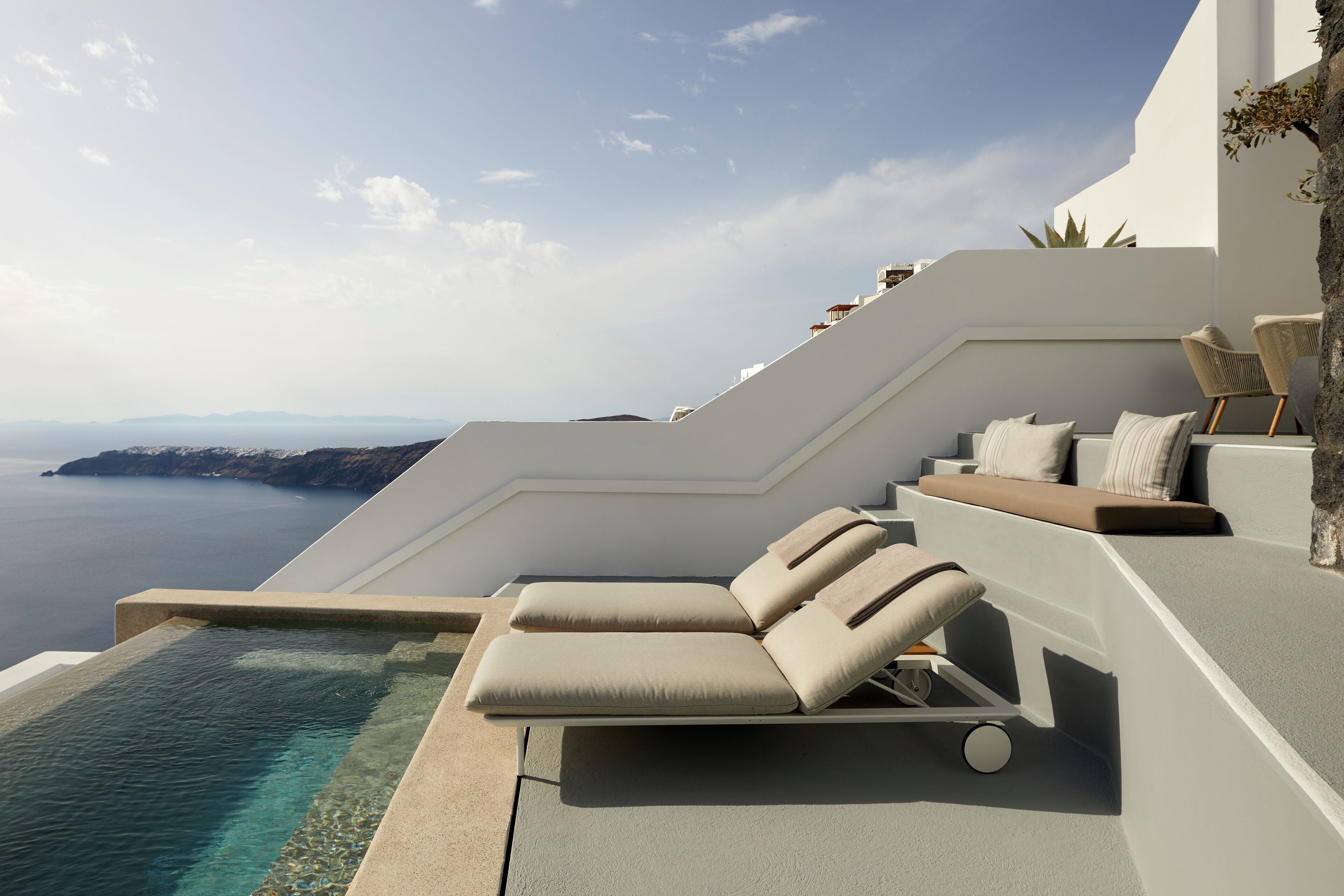 En modern infinitypool med fri utsikt över havet och de avlägsna bergen.