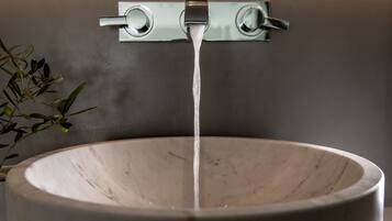 A marble sink with water flowing from a modern faucet.