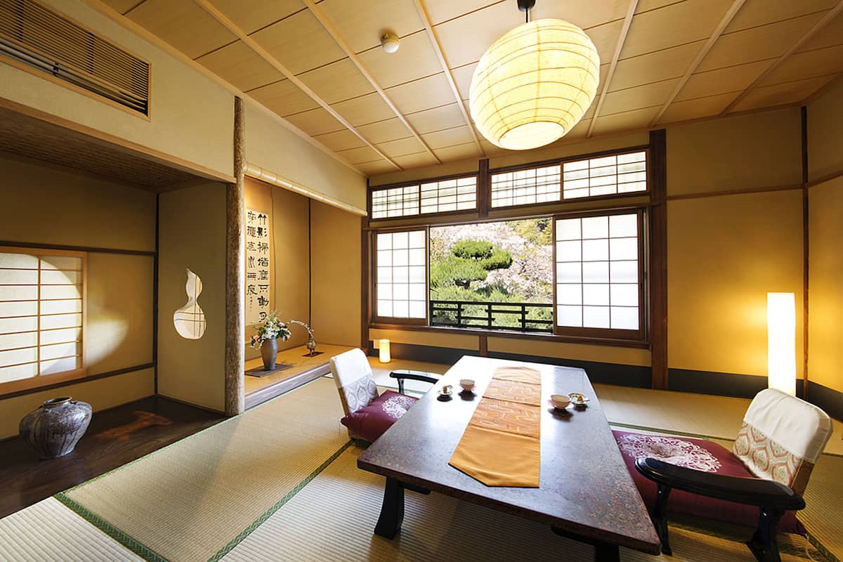 A traditional Japanese room with tatami flooring, a low table, and sliding doors.