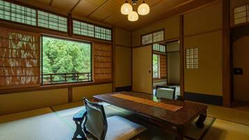 A traditional Japanese room with tatami flooring, a low table, a bench, and sliding doors.