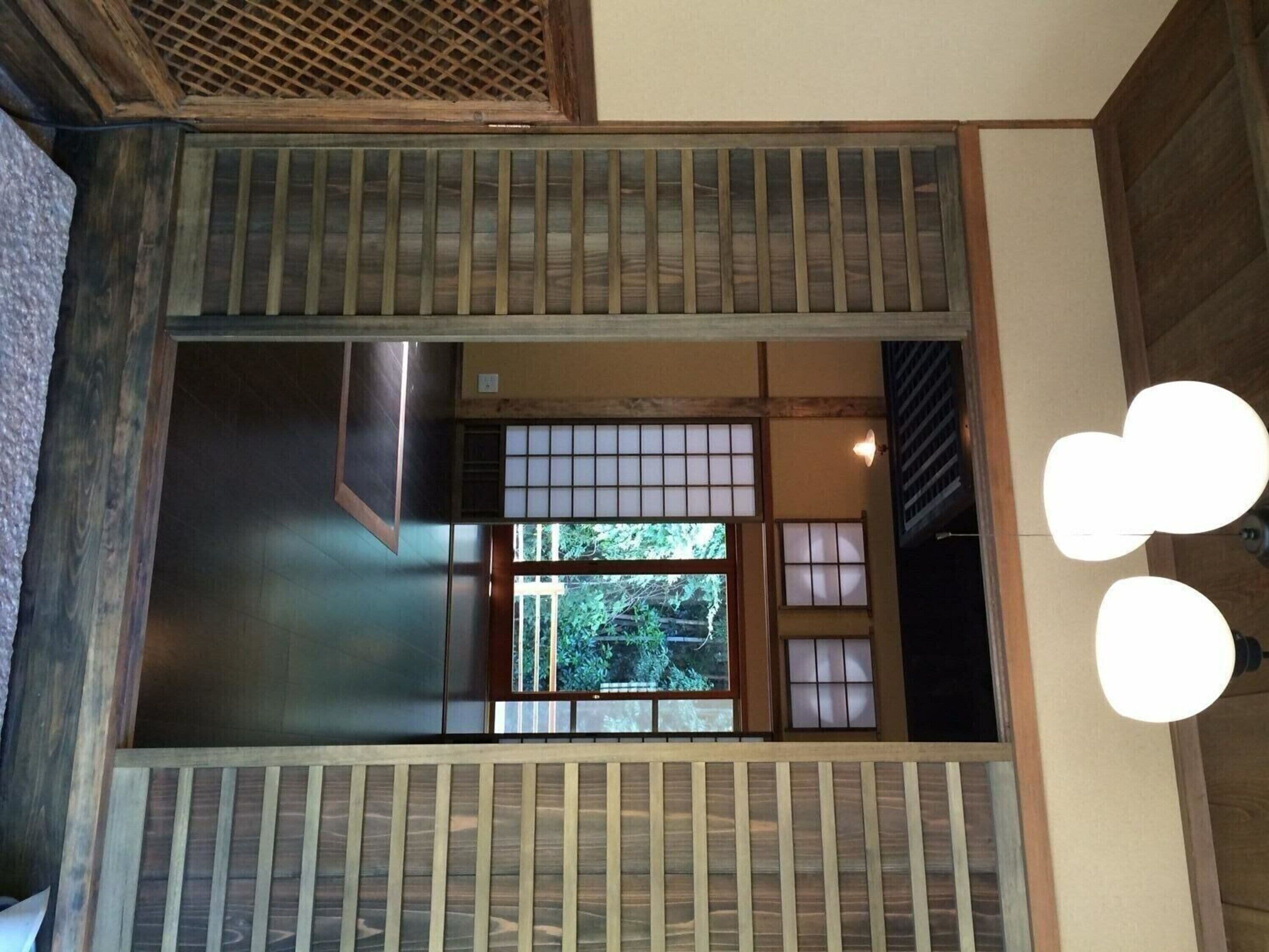 Ein traditionelles japanisches Interieur mit Tatami-Böden, Shoji-Schirmen und Blick ins Grüne.