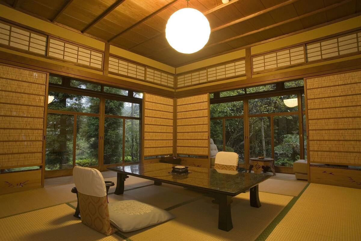 A traditional Japanese room with tatami flooring, a low table, and sliding doors.