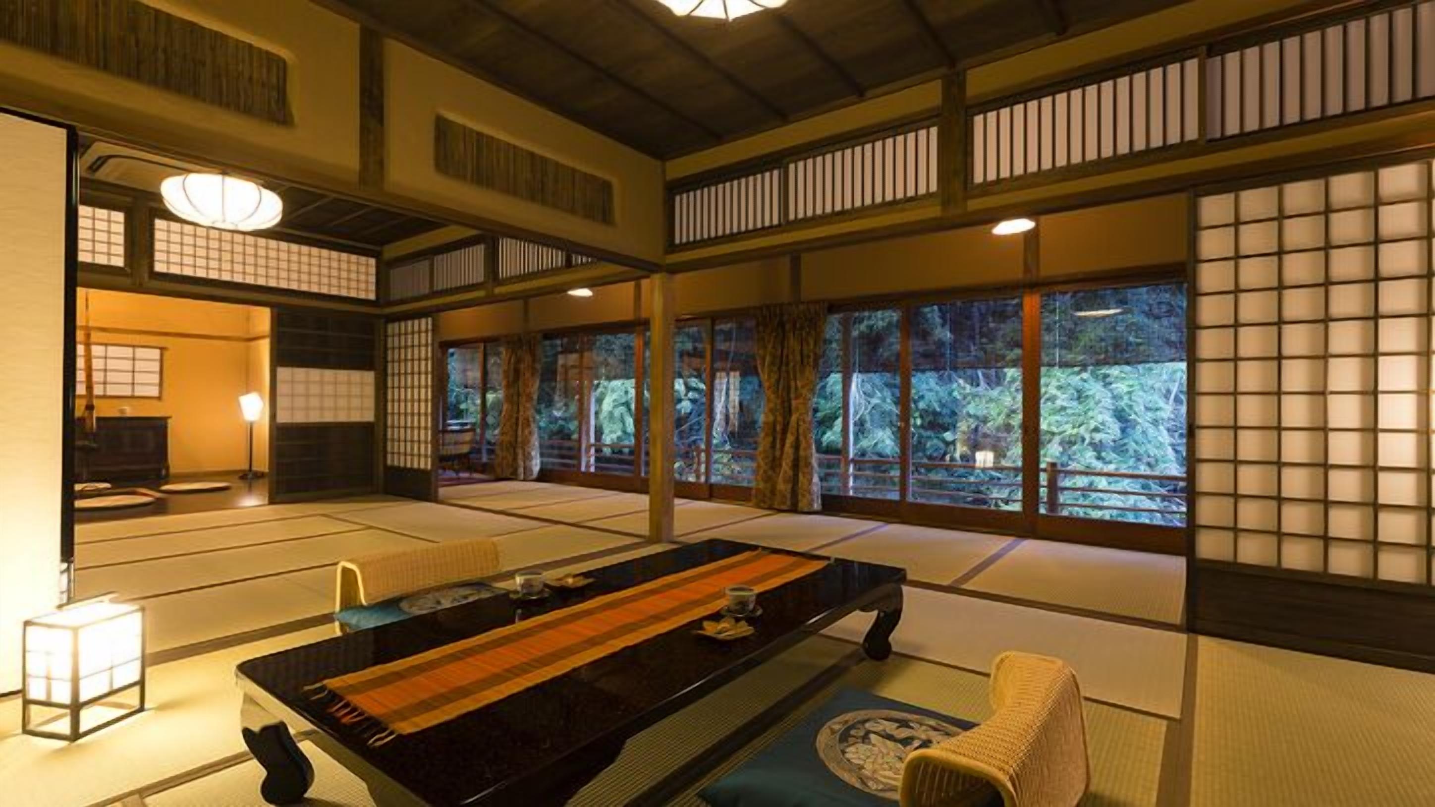 A traditional Japanese room with tatami flooring, a low table, and sliding doors.