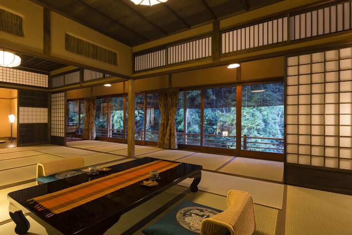 A traditional Japanese room with tatami flooring, a low table, and sliding doors.