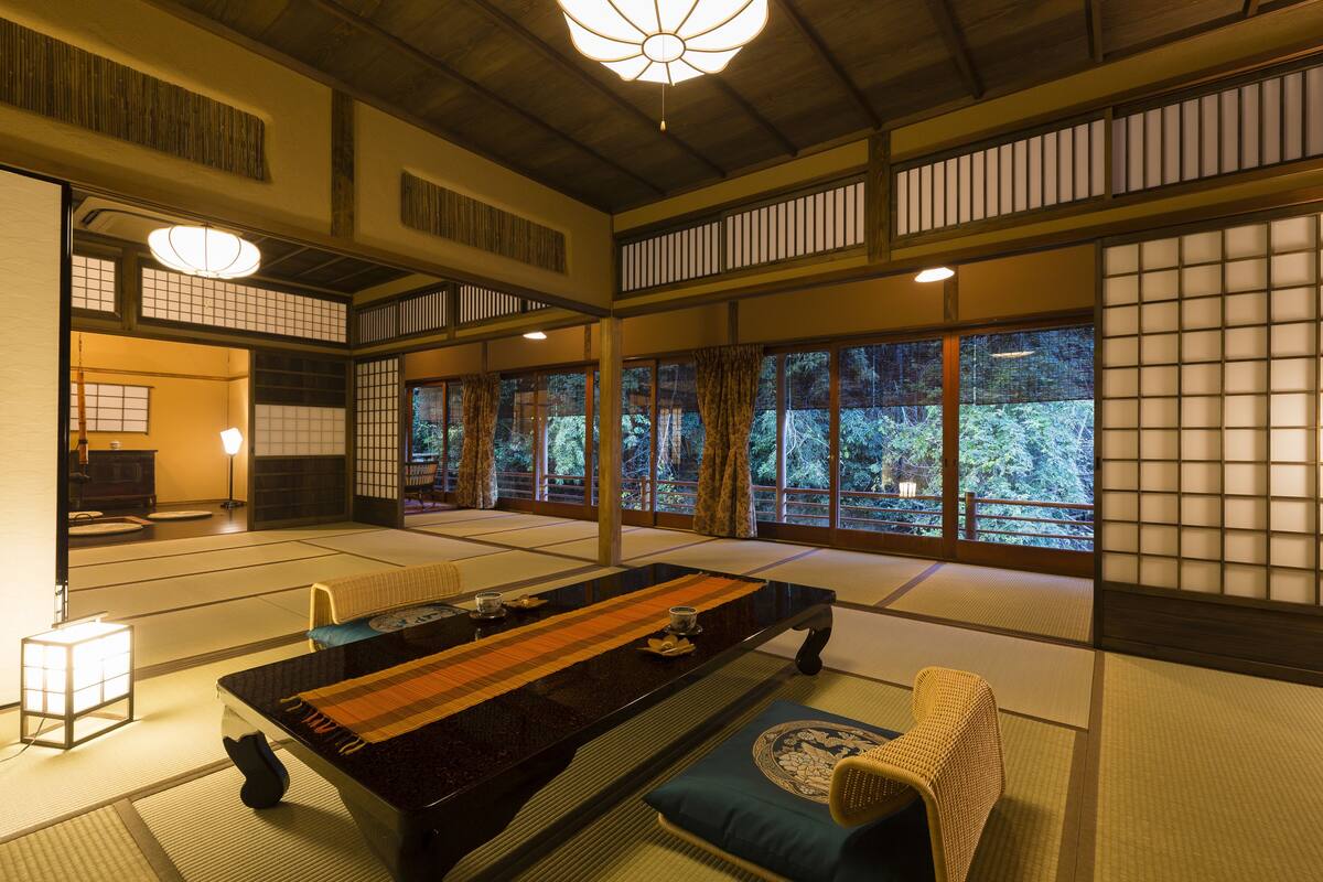 A traditional Japanese room with tatami flooring, a low table, and sliding doors.