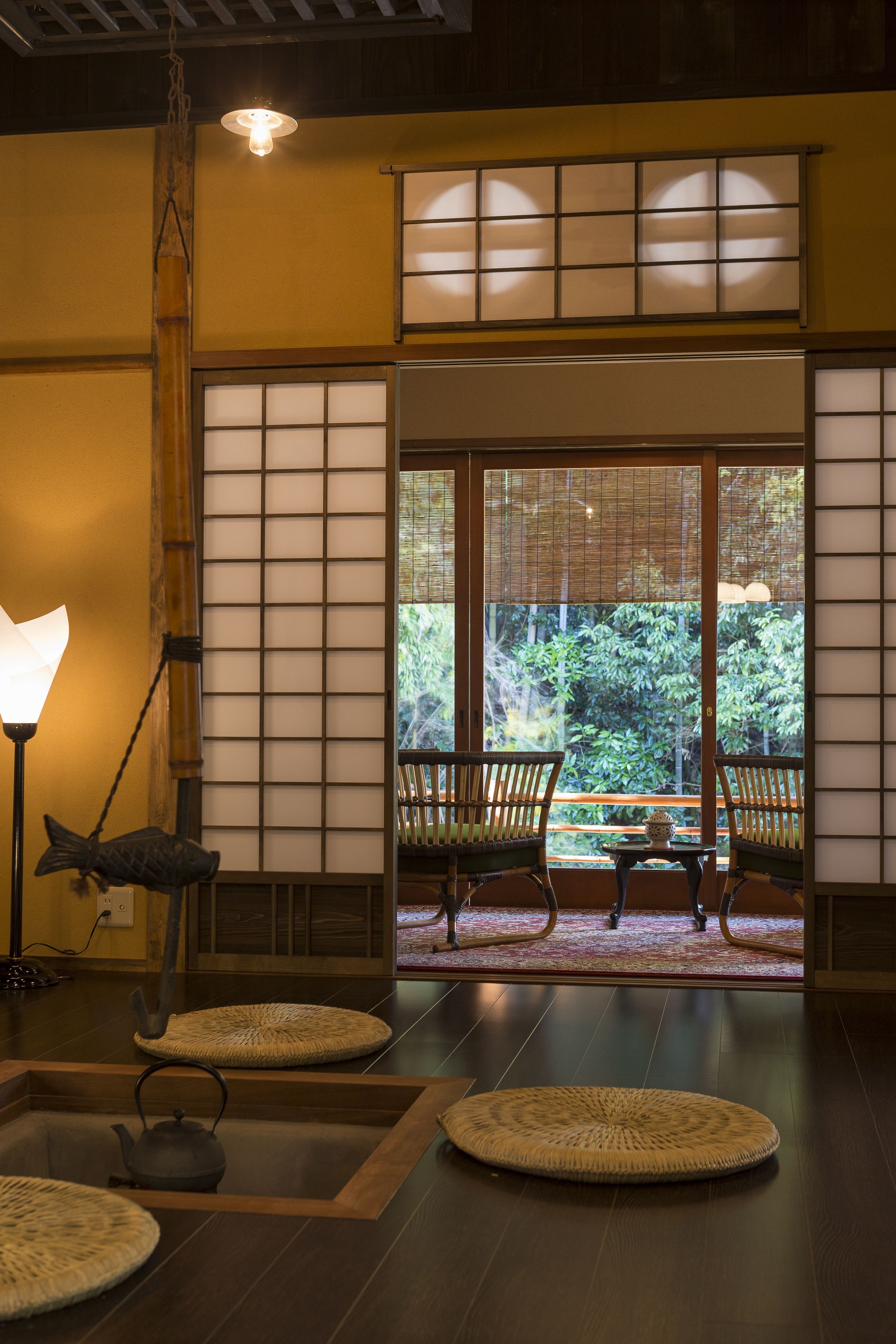 A traditional Japanese interior with tatami mats, a tea set, and sliding doors leading to a garden.