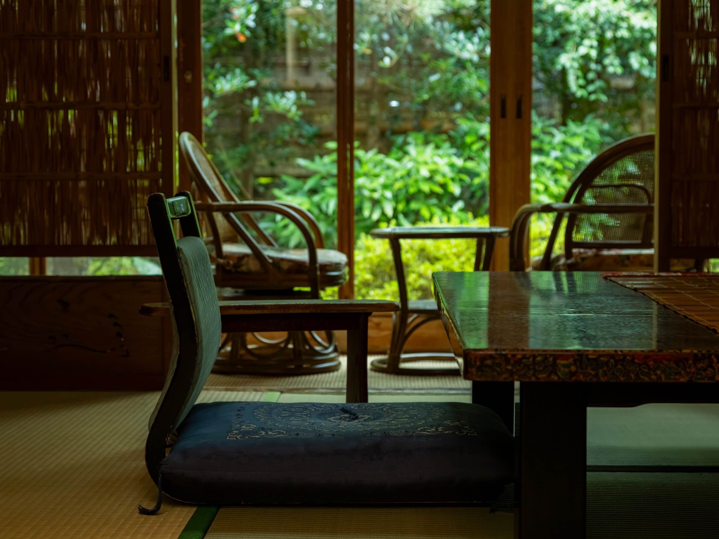 A room with tatami flooring, a low table, and traditional wooden furniture.
