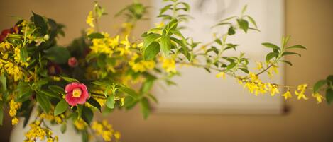 Un vase avec des fleurs jaunes et une seule fleur rouge.
