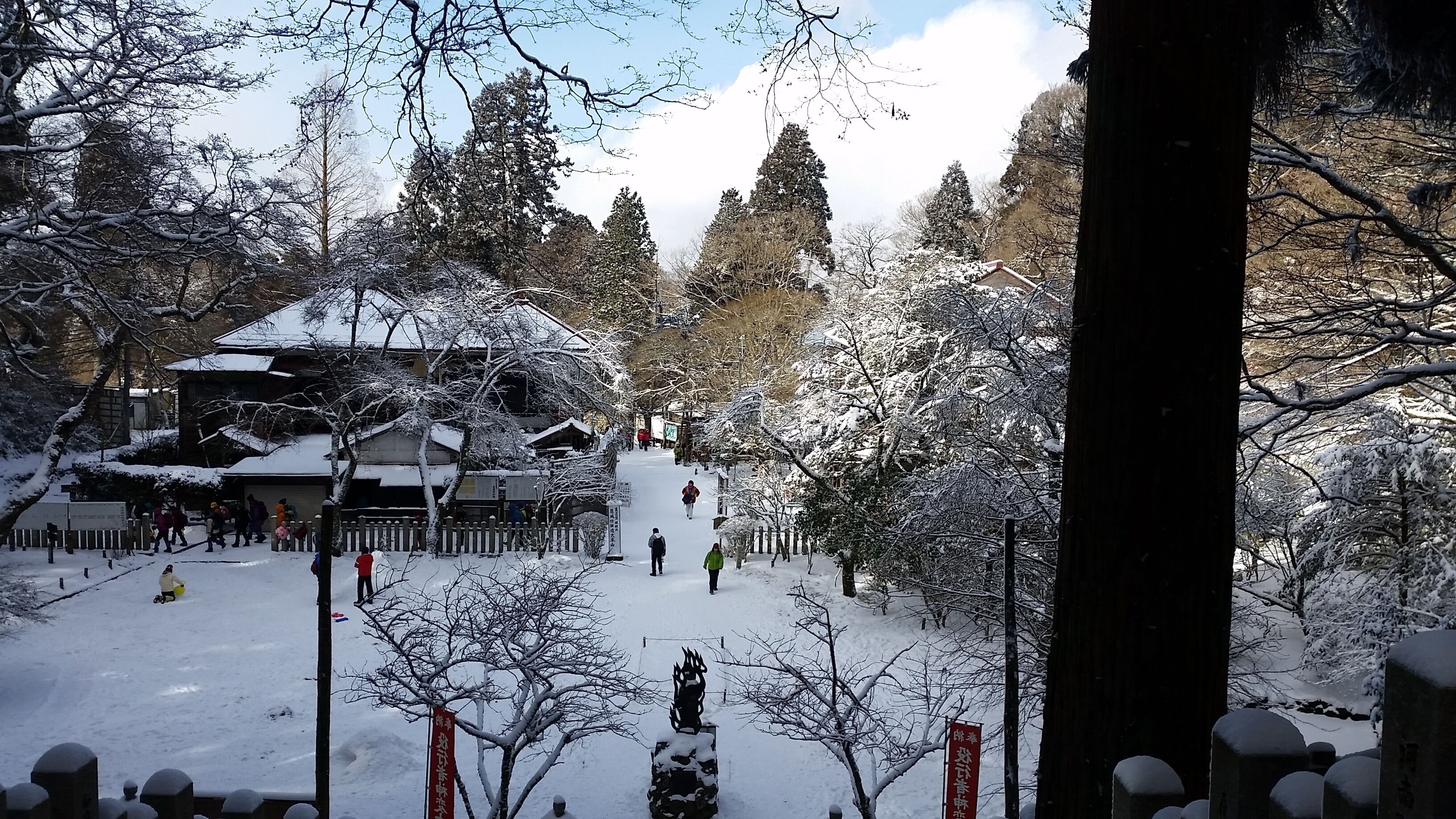A snow-covered pathway leading to a traditional building with a sloped roof.