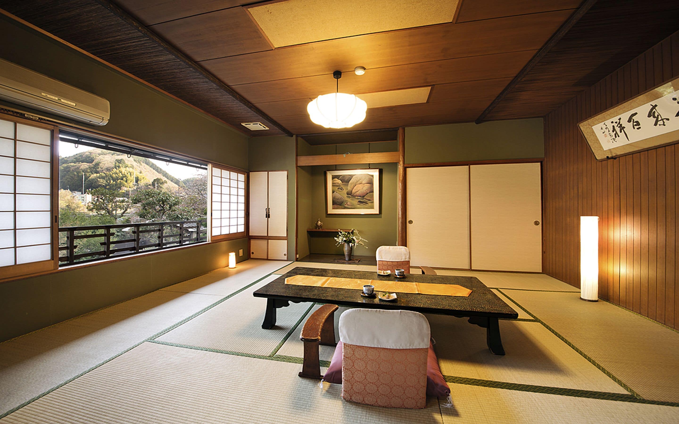 Una tradizionale stanza giapponese con pavimento in tatami, un tavolino basso, una panca e porte scorrevoli.