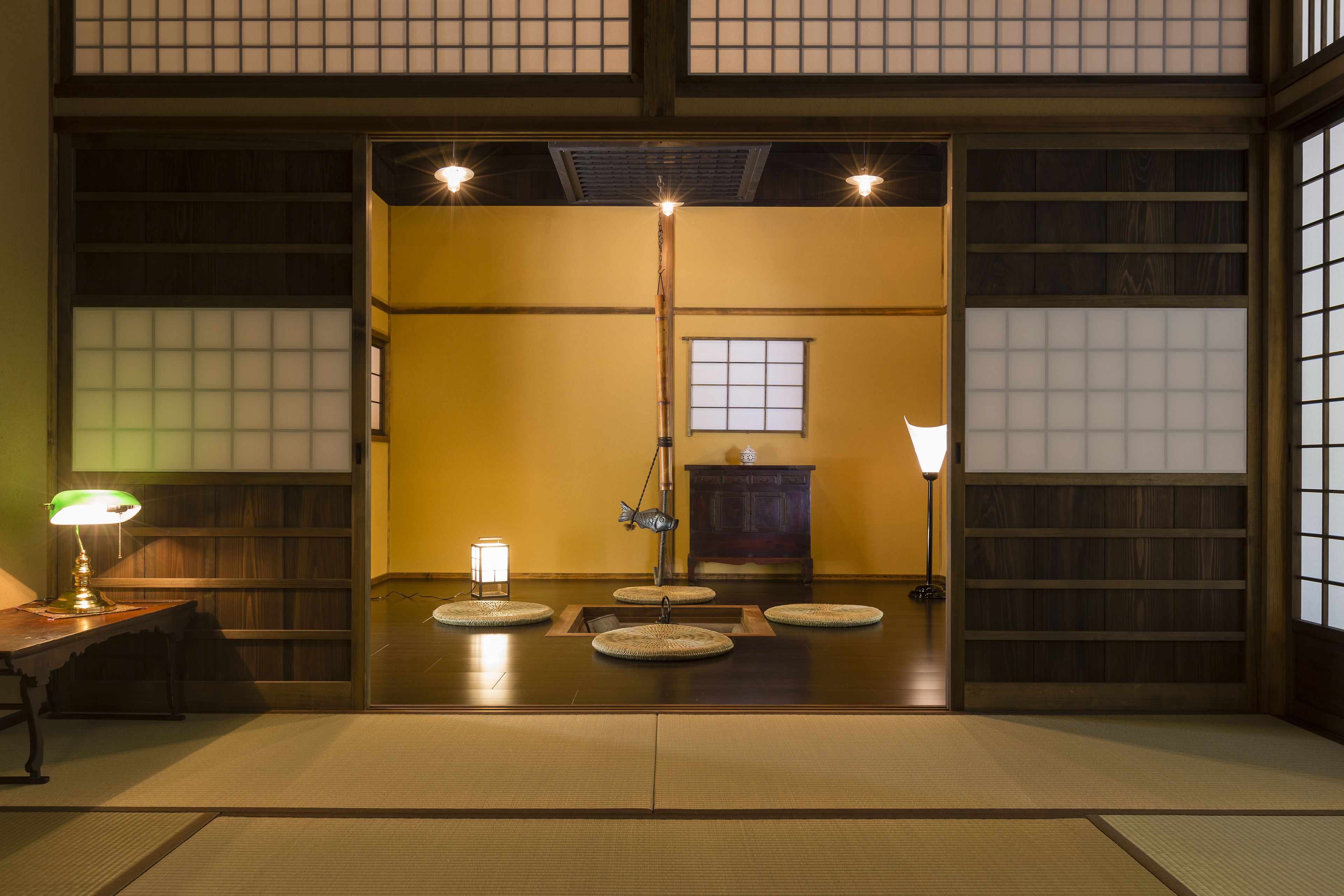 Una habitación japonesa tradicional con suelo de tatami, una mesa baja y una puerta corredera.