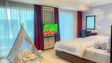 Une chambre avec un lit, une télévision, un espace de jeu aménagé comme une tente et un mur décoré d’un personnage de dessin animé.