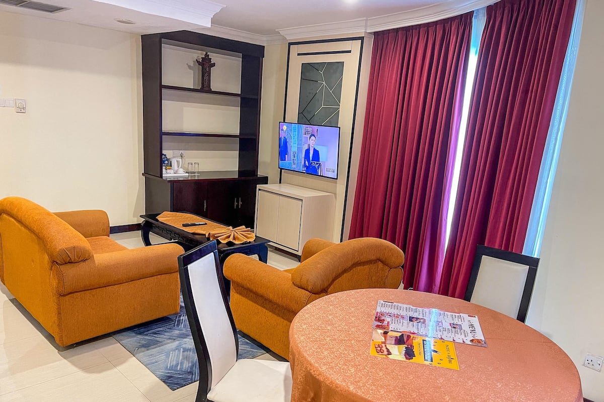 A living room with two sofas, a coffee table, a TV, and a cabinet.