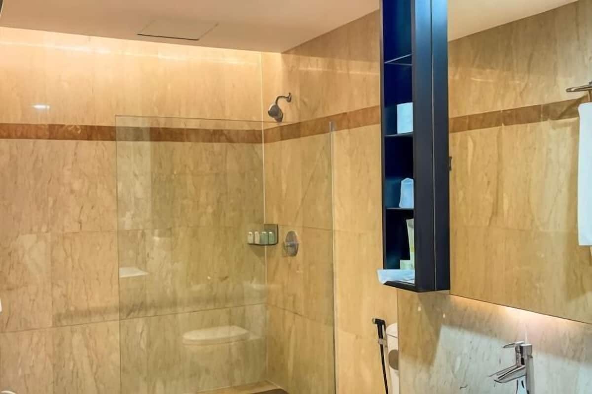 A modern bathroom with a glass-enclosed shower, a built-in sink, and a mirror cabinet.