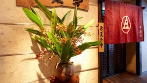 A wooden wall with a sign that reads "Shokudo" and a red banner with a logo. - Hotel Taira (Naha)