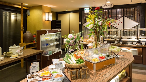 A buffet setup with various food items and a floral centerpiece. - Hotel Taira (Naha)