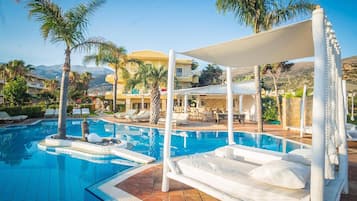 Una piscina al aire libre de temporada, sombrillas