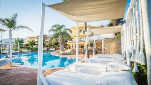 En säsongsöppen utomhuspool, parasoller och solstolar