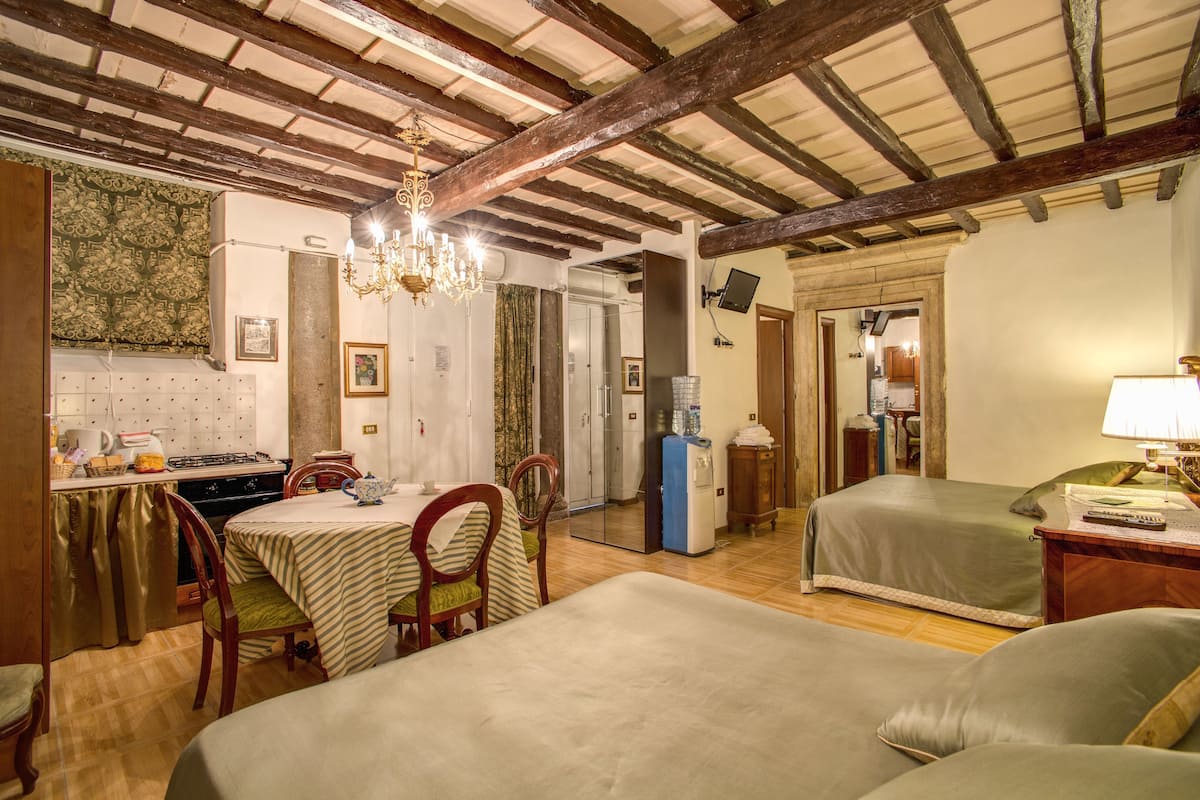 A cozy room with a dining area, a bed, and a kitchenette.