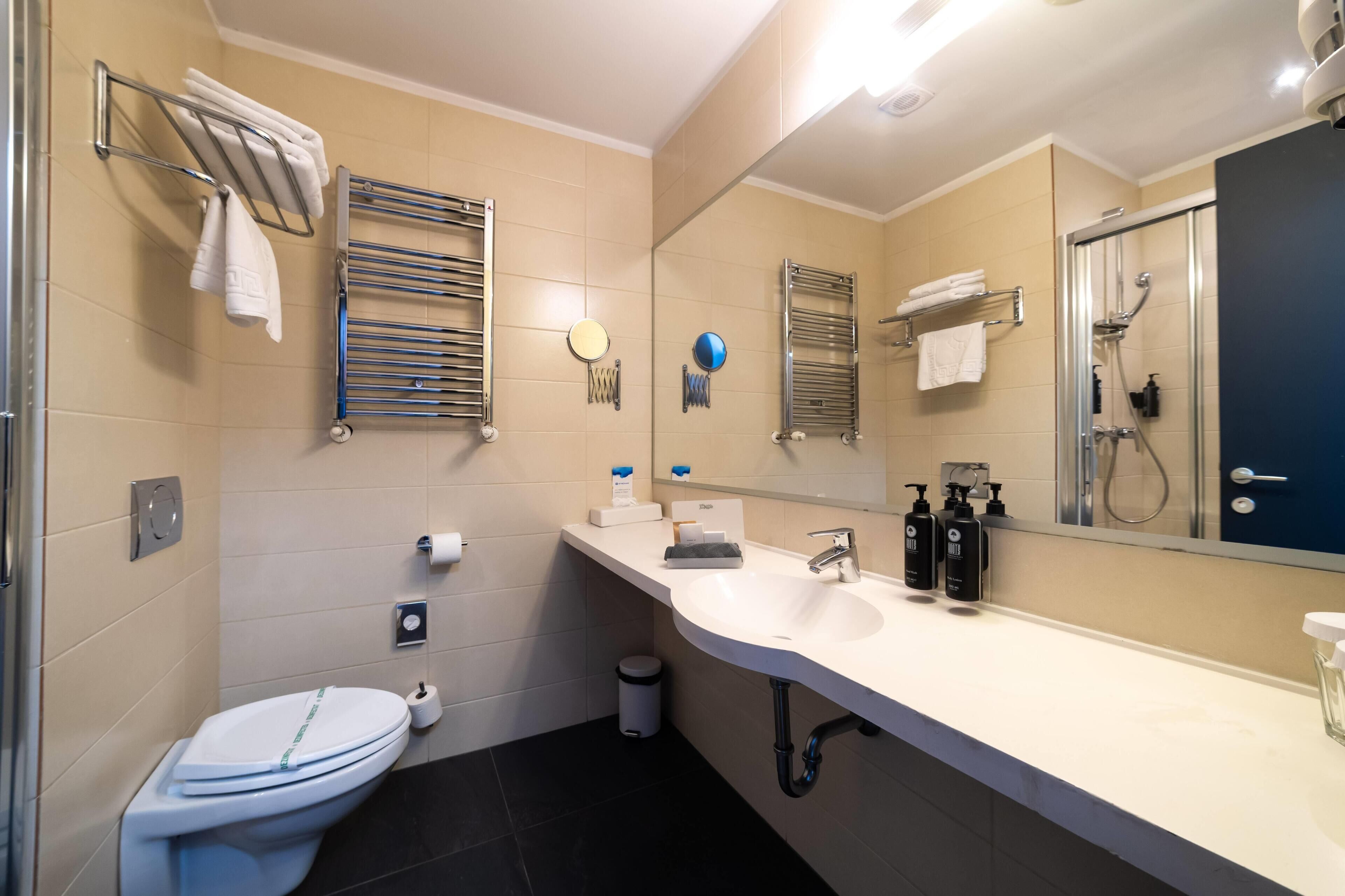 A modern bathroom with a toilet, sink, and shower.