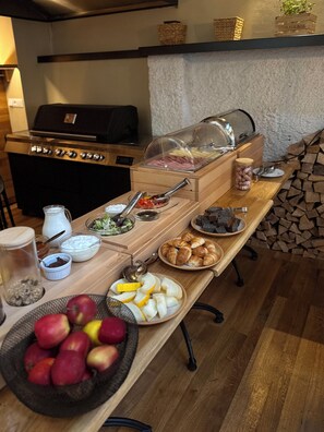 A breakfast buffet with various food items, a grill, and a storage box labeled "STORAGE BOX".