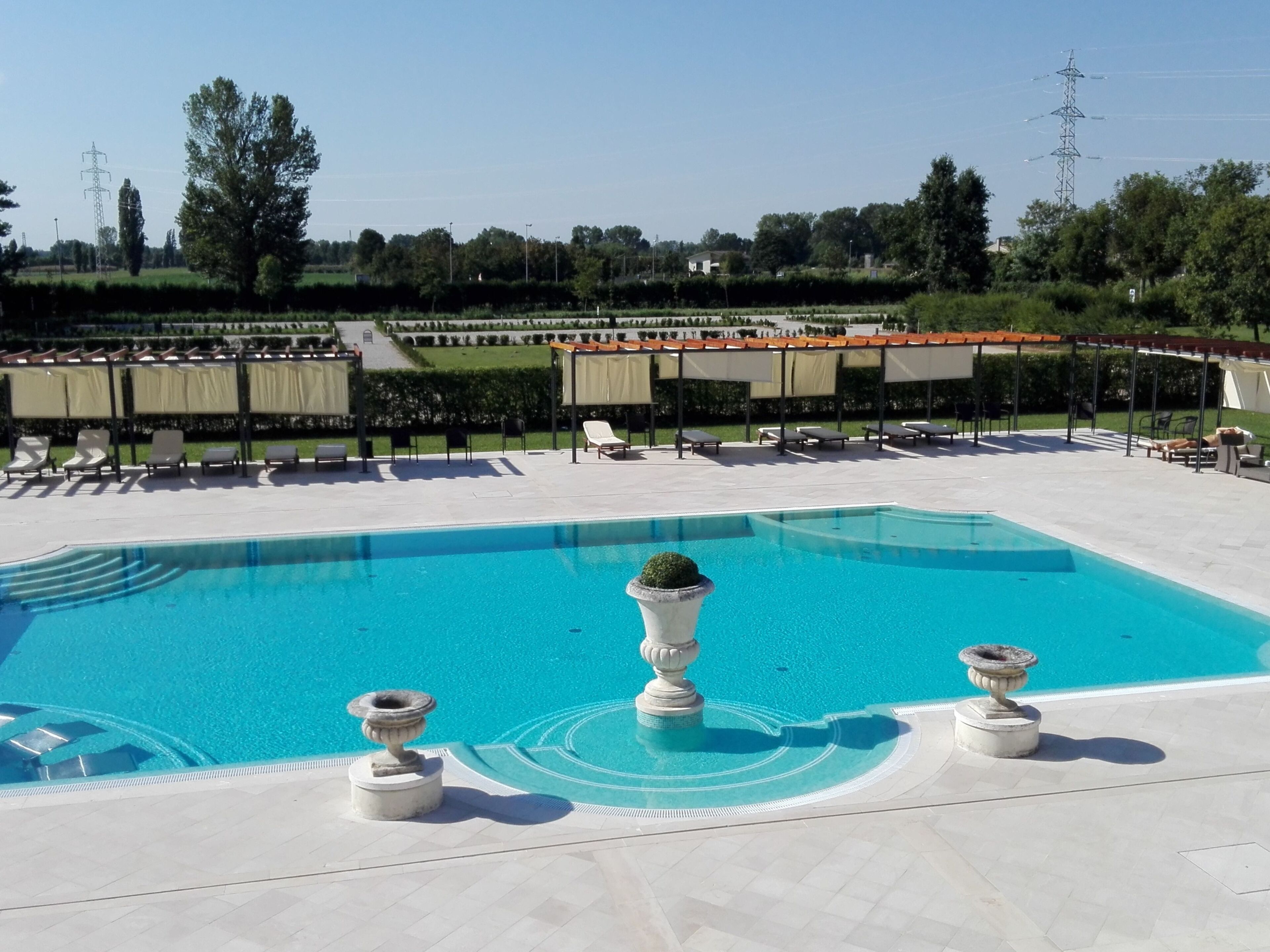 A swimming pool with lounge chairs and a pergola.