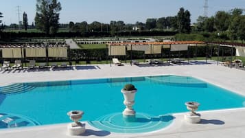A swimming pool with lounge chairs and a pergola.