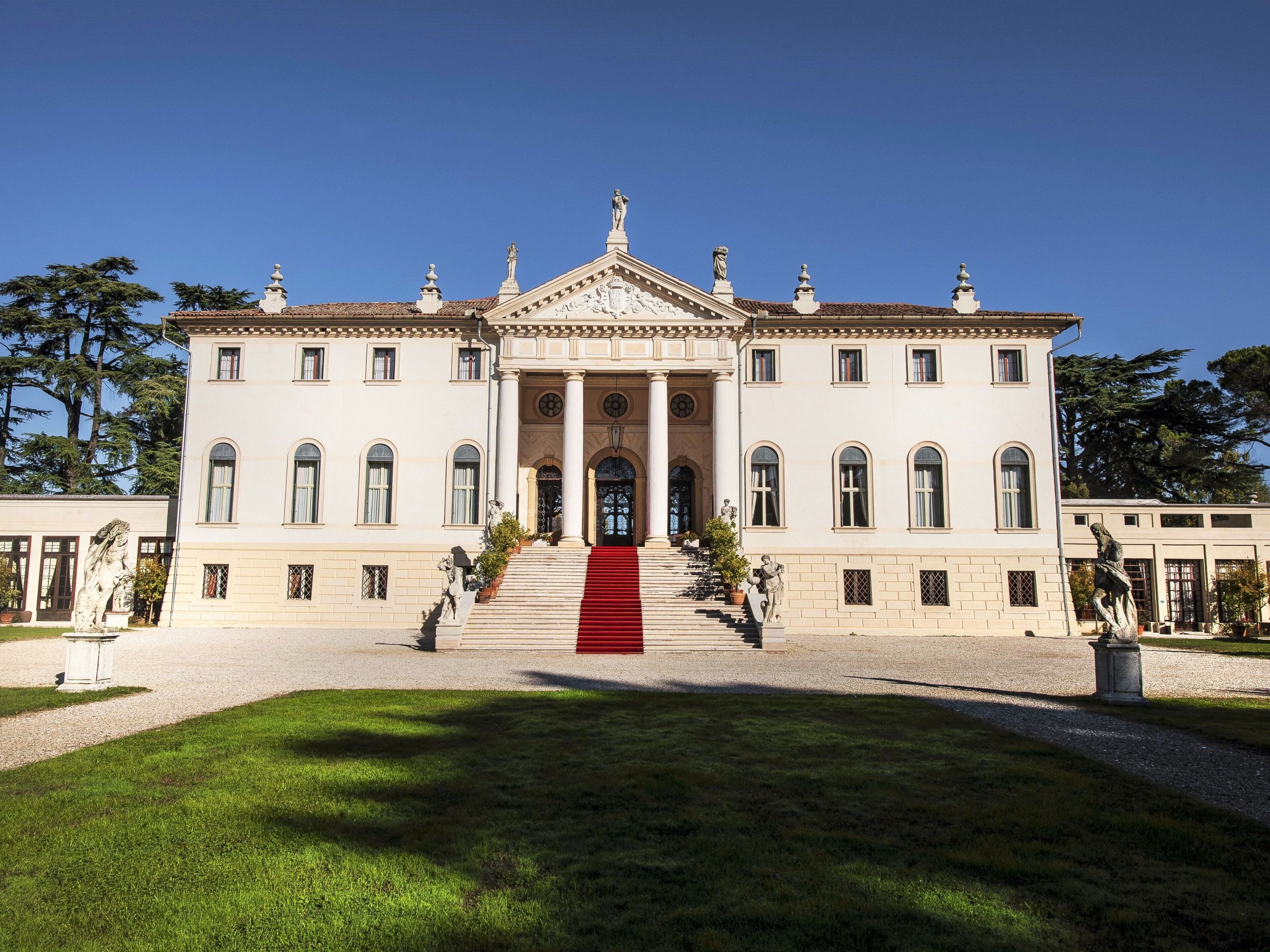 A large, symmetrical building with a central entrance, columns, and statues.