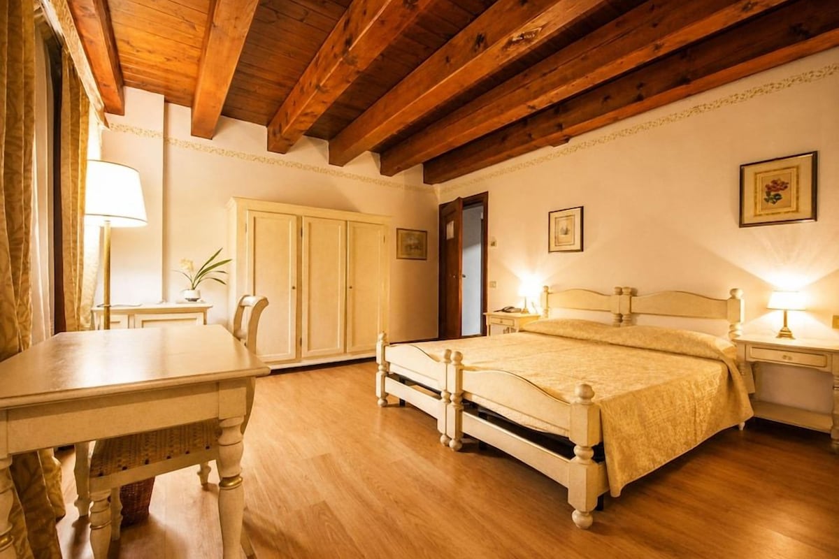 Une chambre à coucher avec un lit en bois, des tables de chevet, un bureau et une chaise.