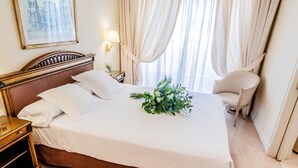Sengetøy av topp kvalitet, dundyner, minibar og safe på rommet